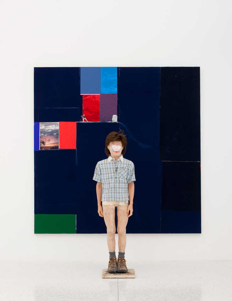 A wax figure installed in front of a canvas