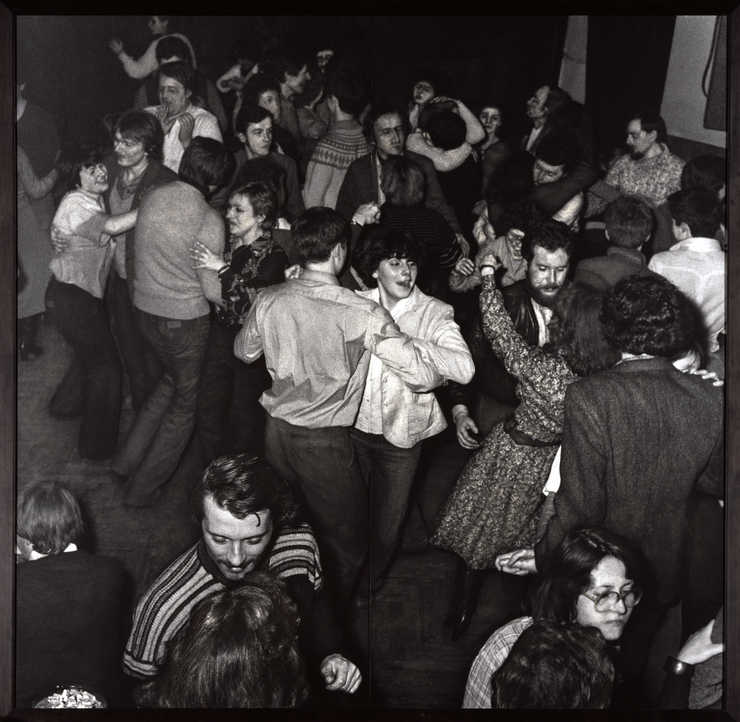 black and white photograph depicting people dancing in a nightclub.