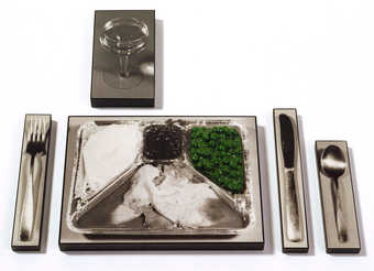 photos of a TV Dinner, Knife, Spoon, Fork, and Glass attached to wood.  The TV dinner has a green...