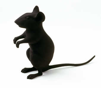 A plastic mouse standing upright painted flat black.