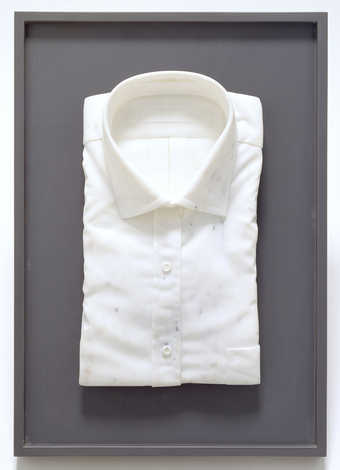 Carved marble in the form of a. folded dress shirt