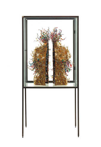Two leather covered torso halves covered with beads.  Exhibited in a steel and glass vitrine