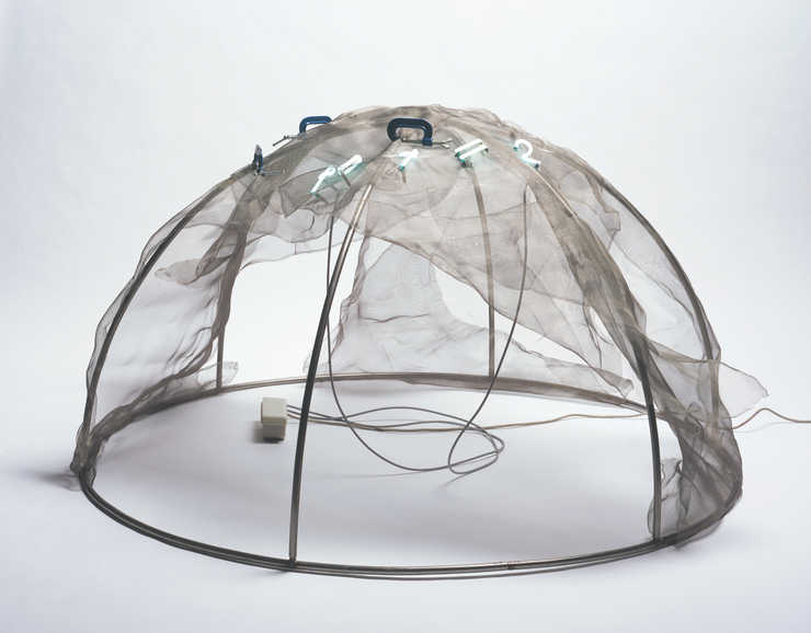 A steel framed igloo draped with wire screen. Blue neon letters mount through the screen to form...