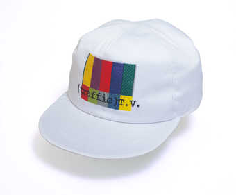 A white baseball style cap with "Traffic TV" embroidered underneath an embroidered...
