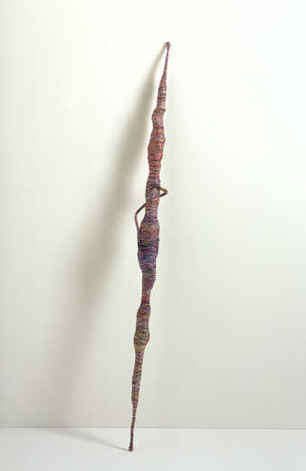 A bamboo stick wrapped with wire, a guitar strap, and a cigarette package, then completly encased...