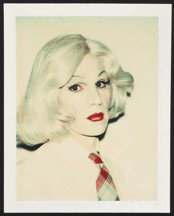 A portrait of Warhol in drag wearing a blonde wig, white shirt and plaid tie.