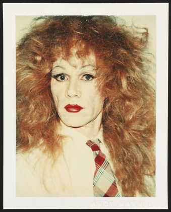 A portrait of Warhol in drag wearing a red wig, white shirt and plaid tie.