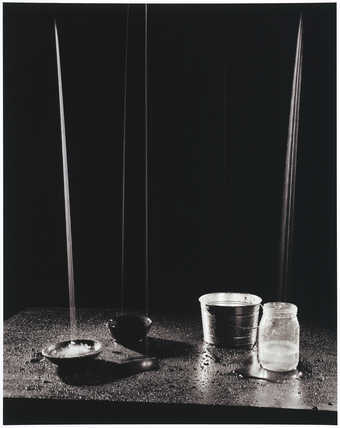 various liquids pouring into jars; black background