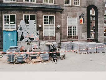 shot of an Aids sculpture with graffiti and surrounded by debris outside of a building