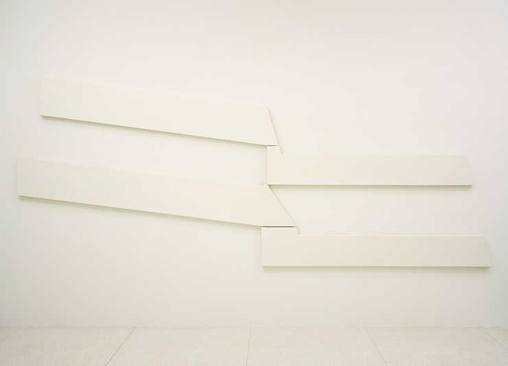 Four white shaped canvases that interlock to create a whole