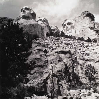An image of the artist standing in front of Mt. Rushmore