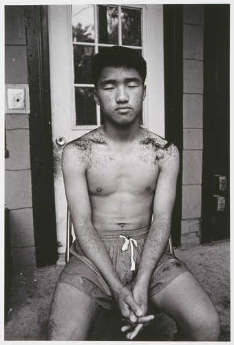 portrait of a seated boy with his eyes closed and covered by hair