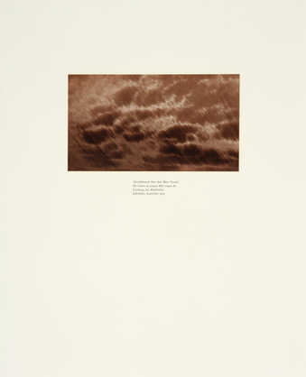 A sepia-toned photograph of a detail of an eagle feather, text in German printed below the image.