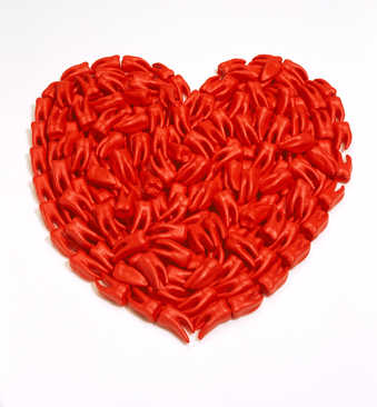 A red paper heart covered with red cast plastic teeth