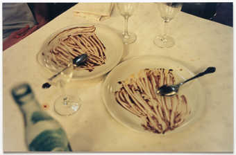 An image of dinner plates on a table patterned with red sauce.