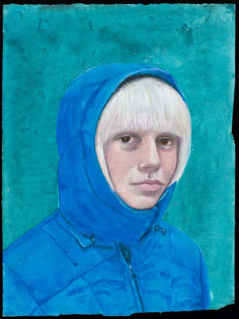 An image of blonde haired woman wearing a blue hooded coat.