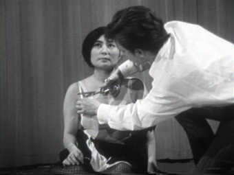 Documentary of a performance in which audience members cut Yoko's clothes from her body with...