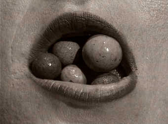 stones rolling in an open mouth; monitor is set into the wall; sound the the stone rolling