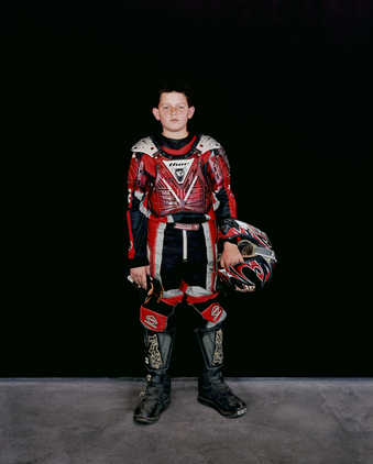 A portraits of boy wearing a motocross outfit.