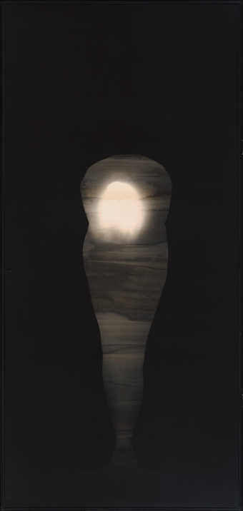 silhouette of a woman bent at the waste holding a globe of light